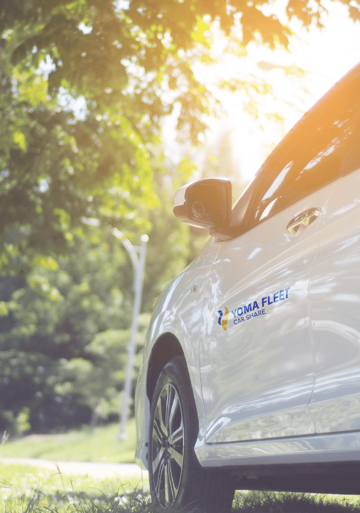 Yoma Car Share white cars parked on the roadside, with natural backgrounds and with bright sunlight